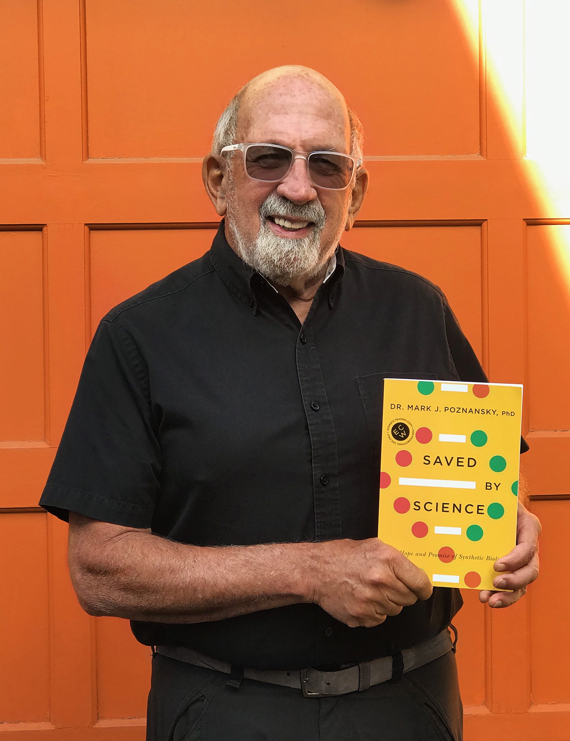 Image of Mark Poznansky standing with his book, "Saved by Science"